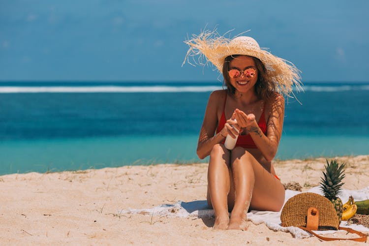 A Woman In The Beach Using A Sun Screen Product