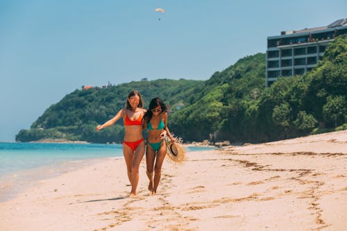 Group of women wearing swimwear and posing on color background