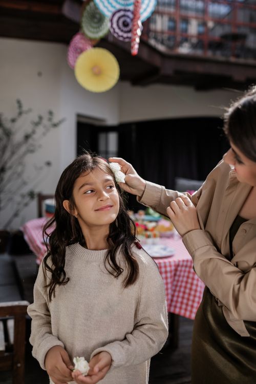 Free A mother and daughter share a joyful moment during a festive gathering indoors. Stock Photo