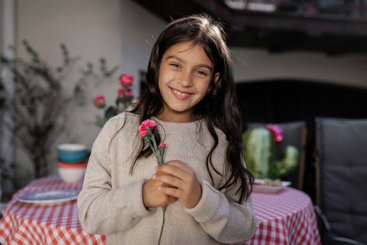 Girl in Beige Sweater Holding Pink Flowers