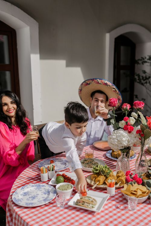 Free A joyful family enjoying a festive meal with Mexican decor and traditional foods. Stock Photo