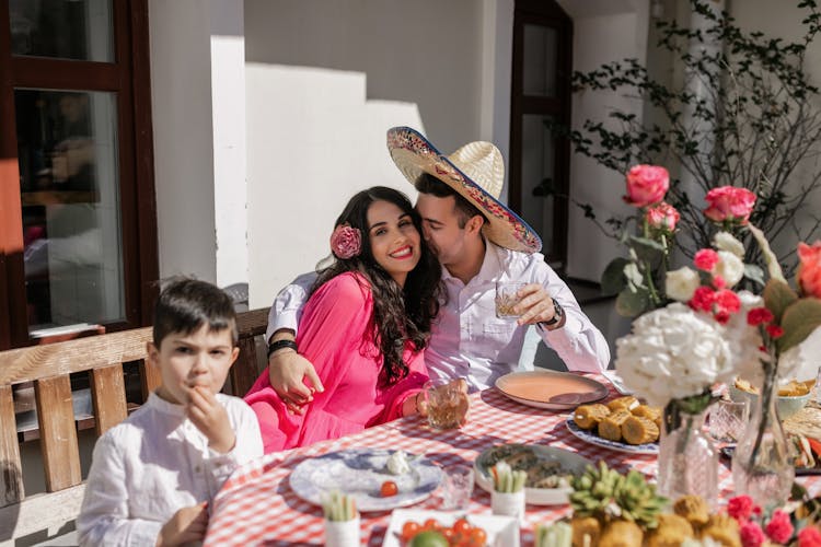 Happy Family Sitting At Table In Restaurant