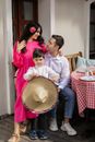Woman in Pink Long Sleeve Shirt Carrying Baby in White and Red Long Sleeve Shirt