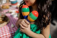 Girl in Green Shirt Holding Red Yellow and Blue Striped Toy