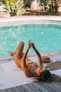 Woman in Yellow Bikini Lying on the Swimming Pool