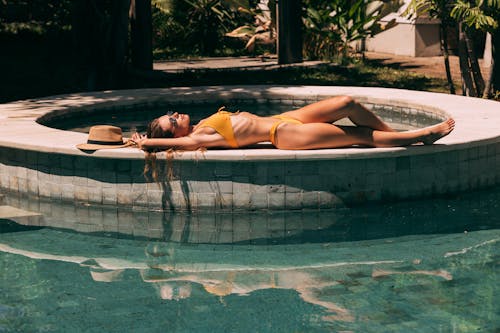A Woman in a Bikini Lying Down Beside the Pool