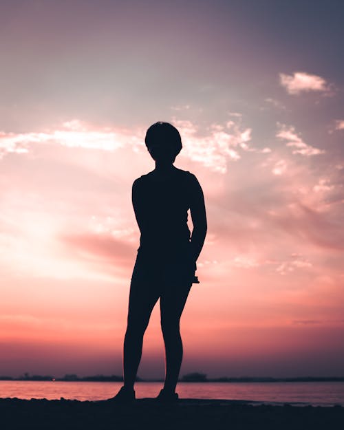 Free Silhouette of Person Standing Near Water Stock Photo