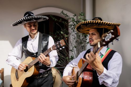 Free Two male musicians in sombreros perform with acoustic guitars outdoors. Stock Photo
