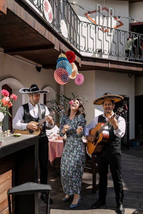 Woman in Dress Dancing with Men in Sombreros Playing Guitars