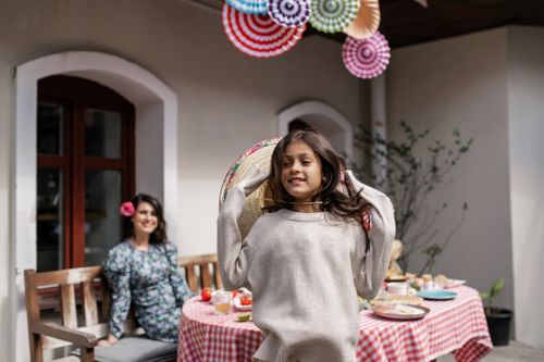 Free A child and adult enjoy a festive outdoor gathering with colorful decor and food. Stock Photo