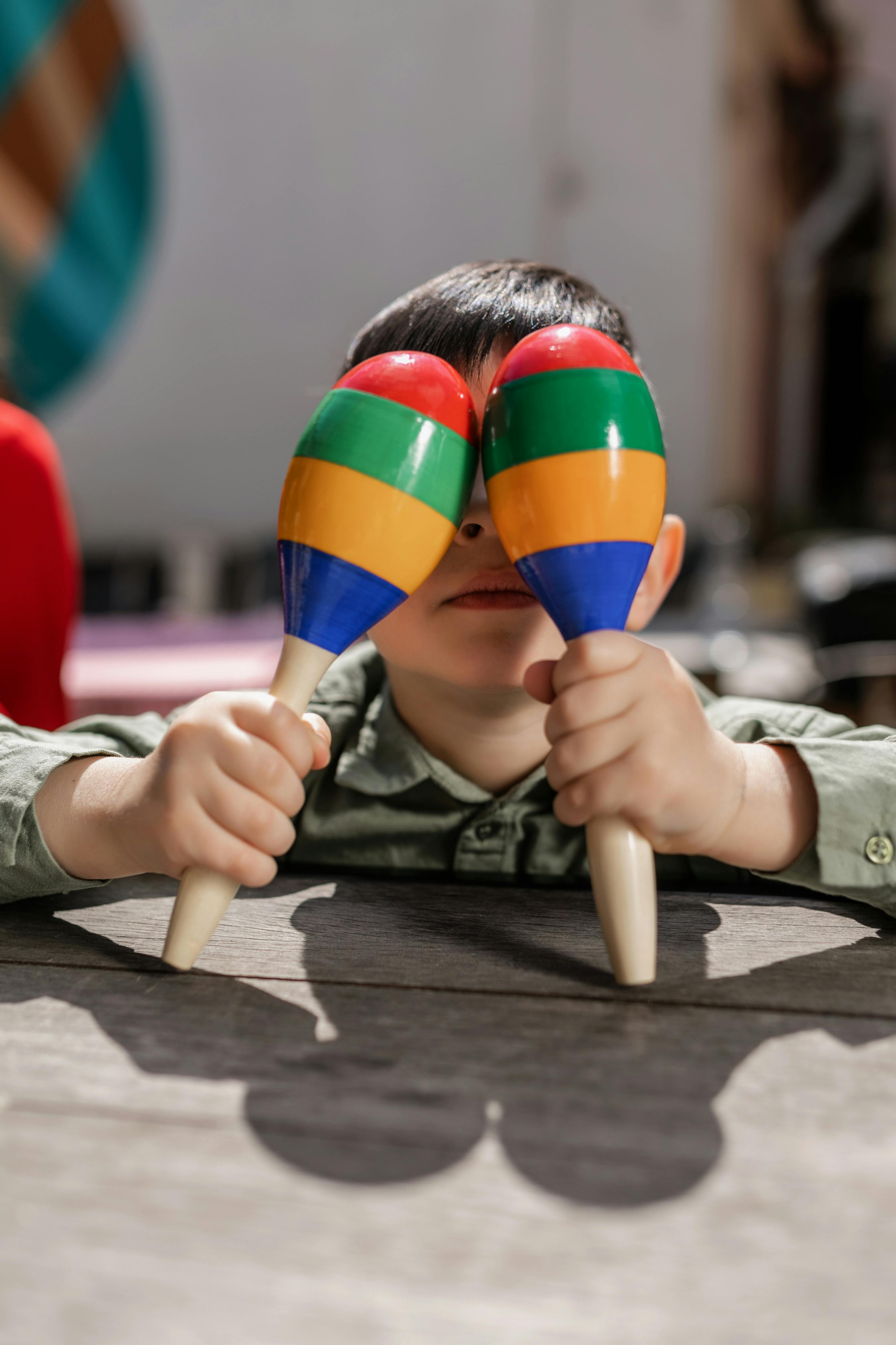 a kid covering his eyes with maracas