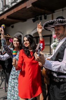 Group enjoying music and dancing with maracas in a lively outdoor setting