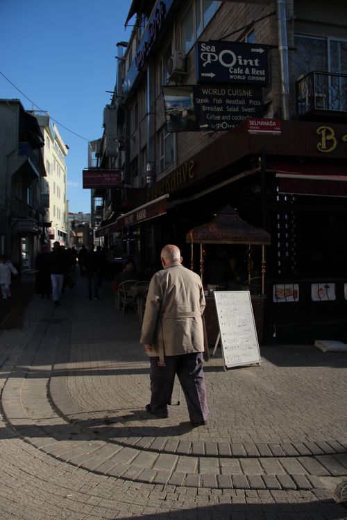 Free A man walks through a sunlit street in İstanbul, Türkiye, capturing urban life. Stock Photo
