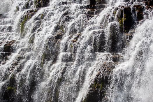 Close-up of a natural cascading waterfall, showcasing flowing water and rocky landscape.