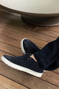 Navy suede lace-ups on a weathered wood deck — photo by Nyara Aquino on Pexels