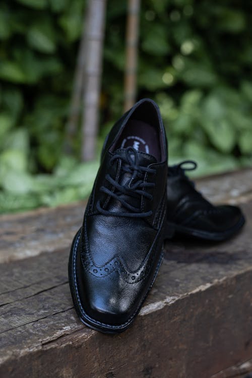 Black Leather Shoes on a Wooden Surface