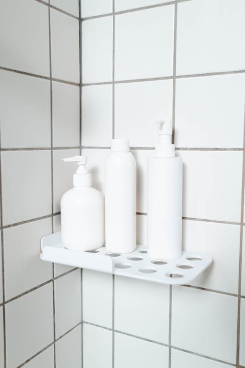 White Plastic Bottles on White Wall Tiles