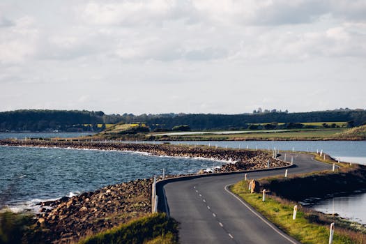 A picturesque winding road along the coast with expansive river and countryside views.