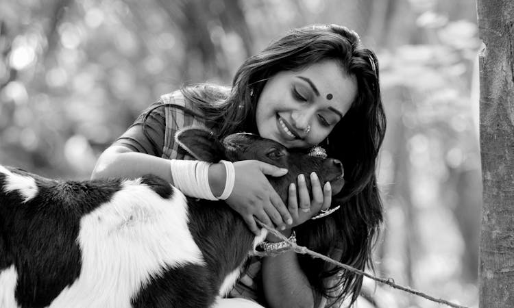 Pretty Woman Hugging A Calf