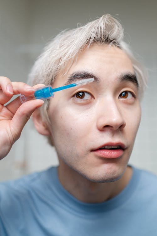 Free Man in Blue Crew Neck Shirt Fixing His Eyebrows Stock Photo