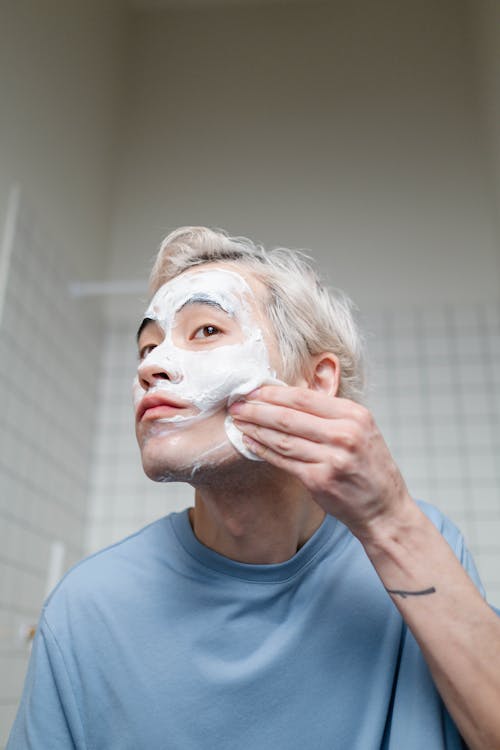 Free Man in Blue Crew Neck Shirt With Cream On Face Stock Photo