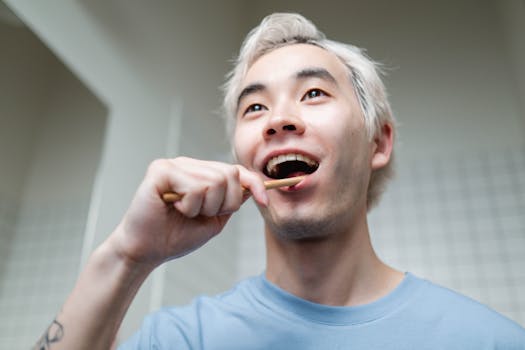 Asian man focusing on dental hygiene with toothbrush in modern bathroom.