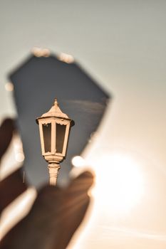 Artistic photo capturing a lamp post reflected in a broken mirror against bright sky.