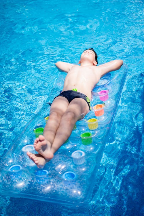 Man Lying on Inflatable Float on Swimming Pool