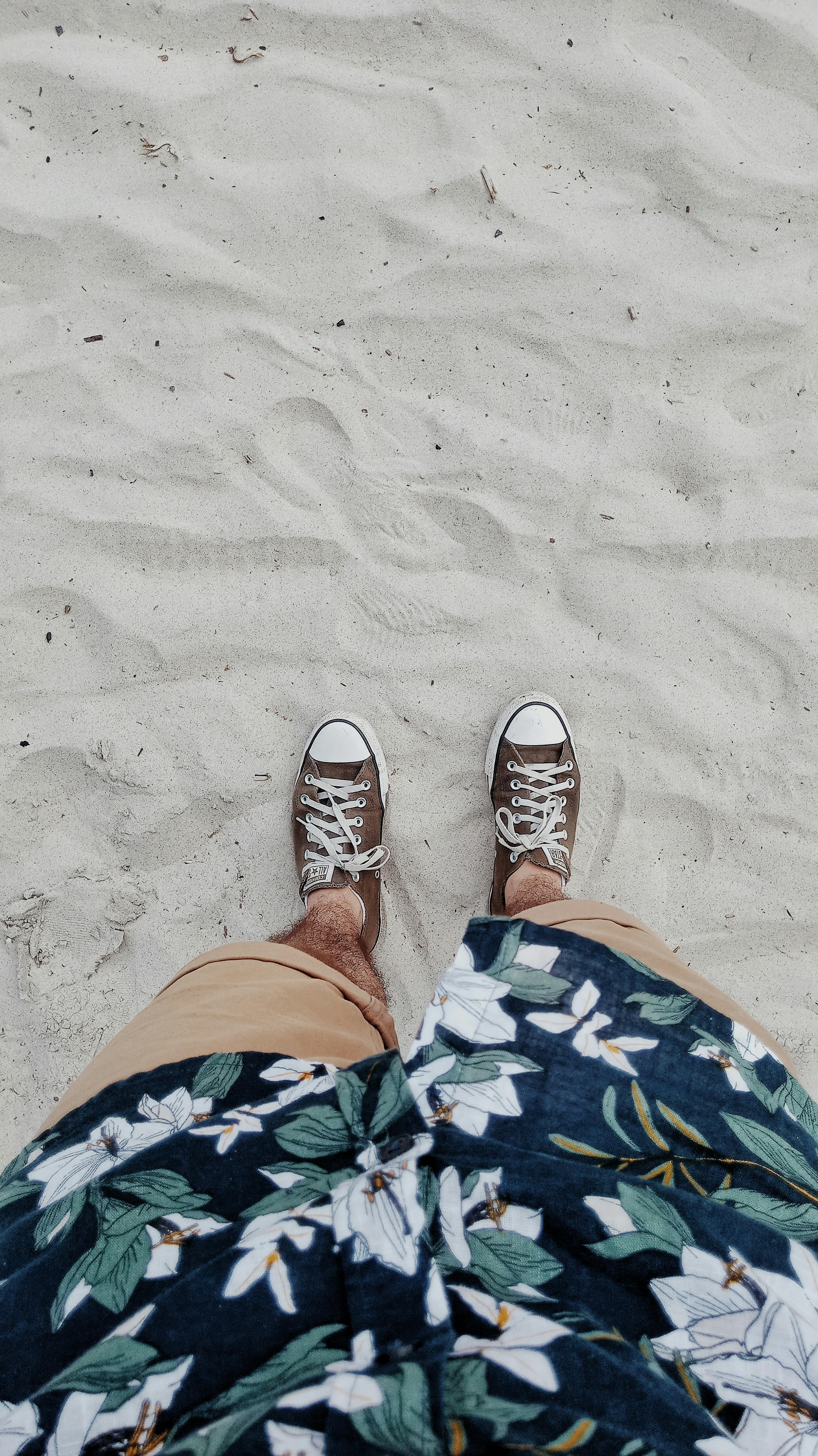 person wearing brown shoes and floral top