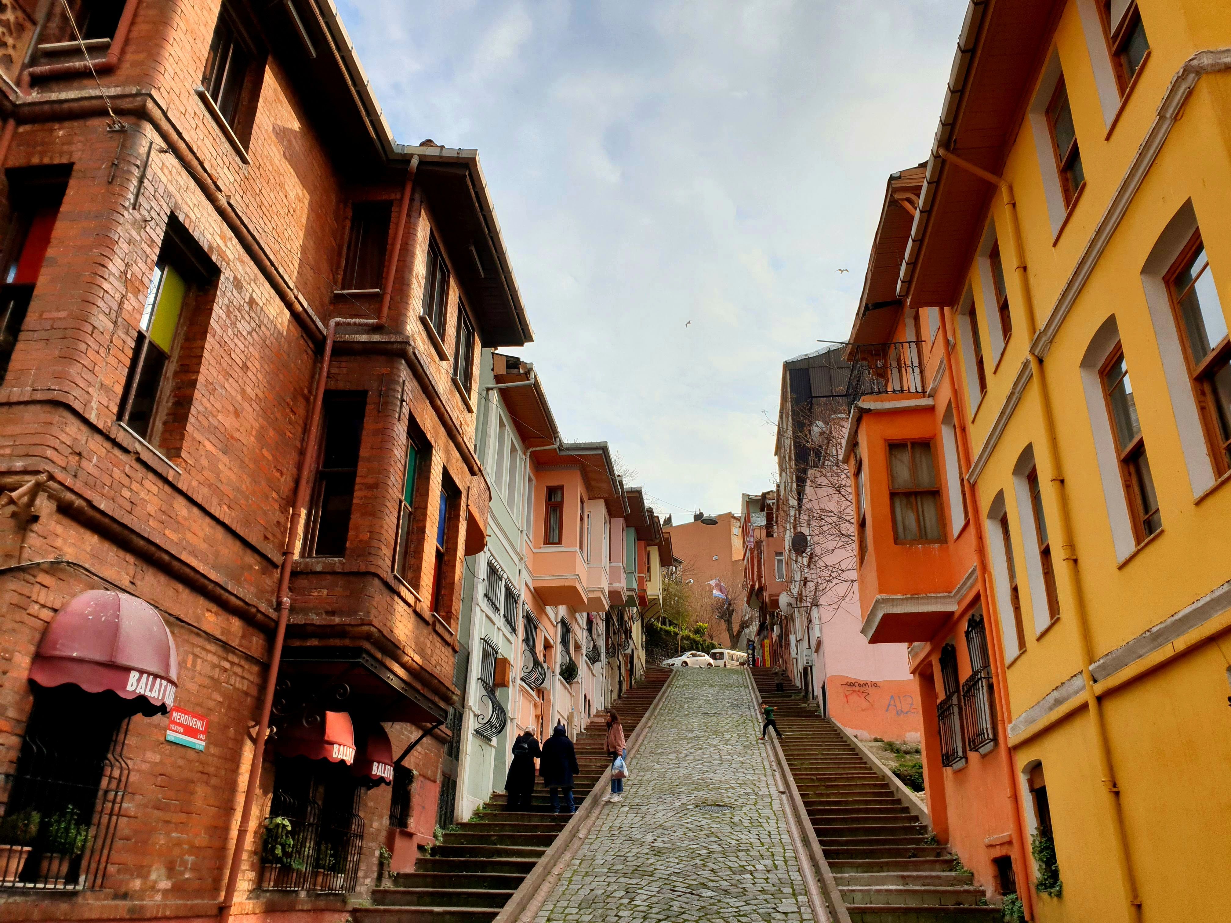 Explore the vibrant, historic streets of Balat in Istanbul, showcasing colorful buildings and cobblestone paths.
