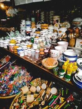 A vibrant display of ceramic tableware and colorful toys in a bustling market setting. - Fotografer Sidoarjo