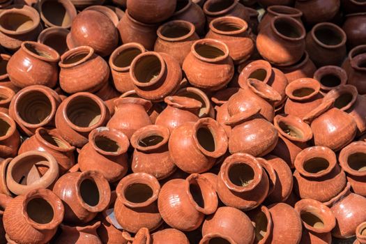 A collection of handmade clay pots displayed in an outdoor market in Mandalay, Myanmar.