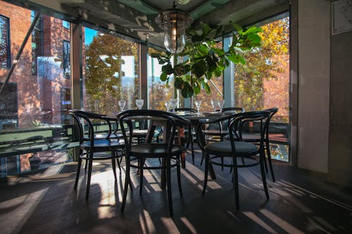 Black  Chairs and Table Inside Dining Area With Glass Windows
