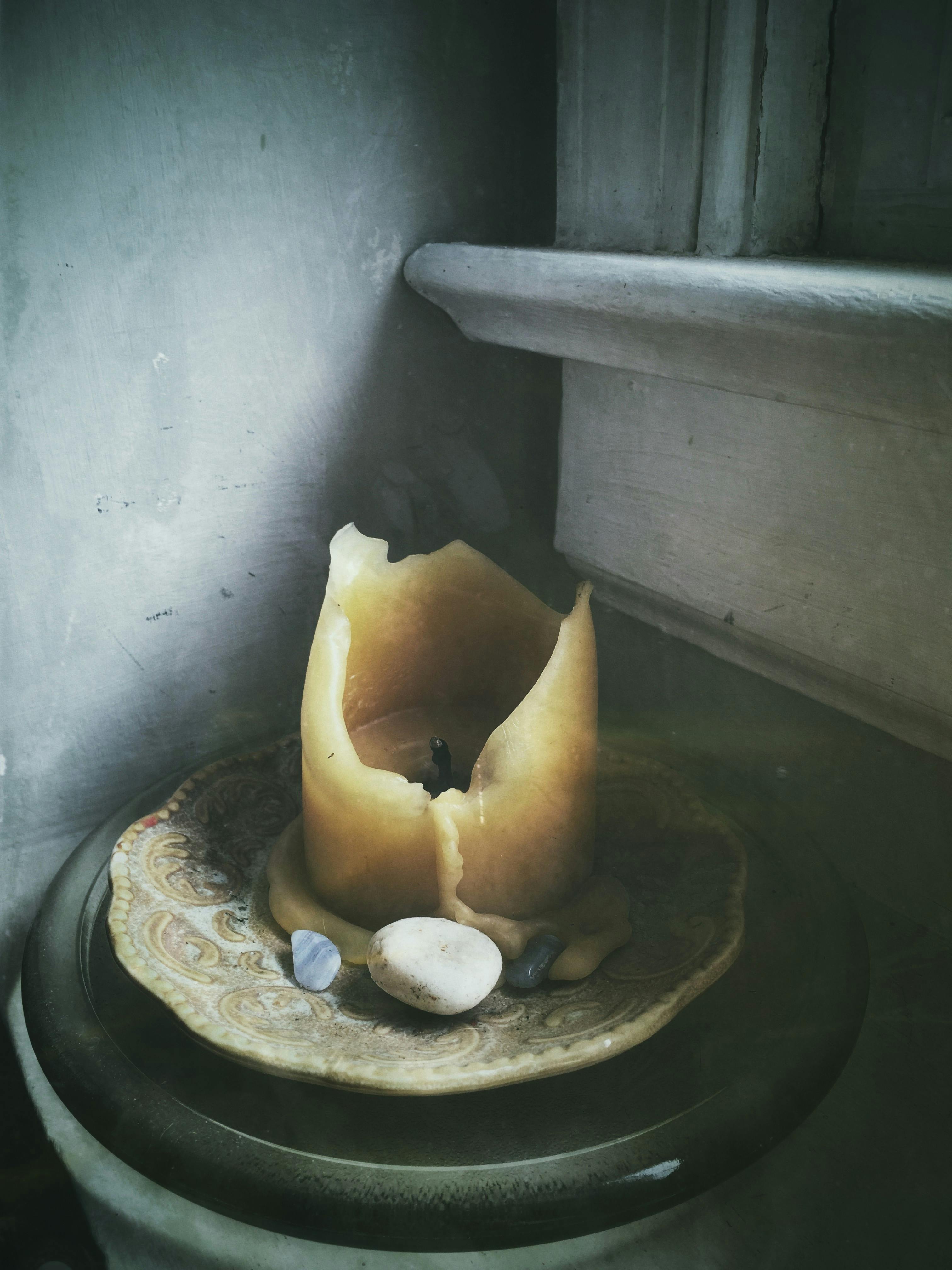 乡村蜡烛与石头在室内装饰板上的特写，氛围阴郁