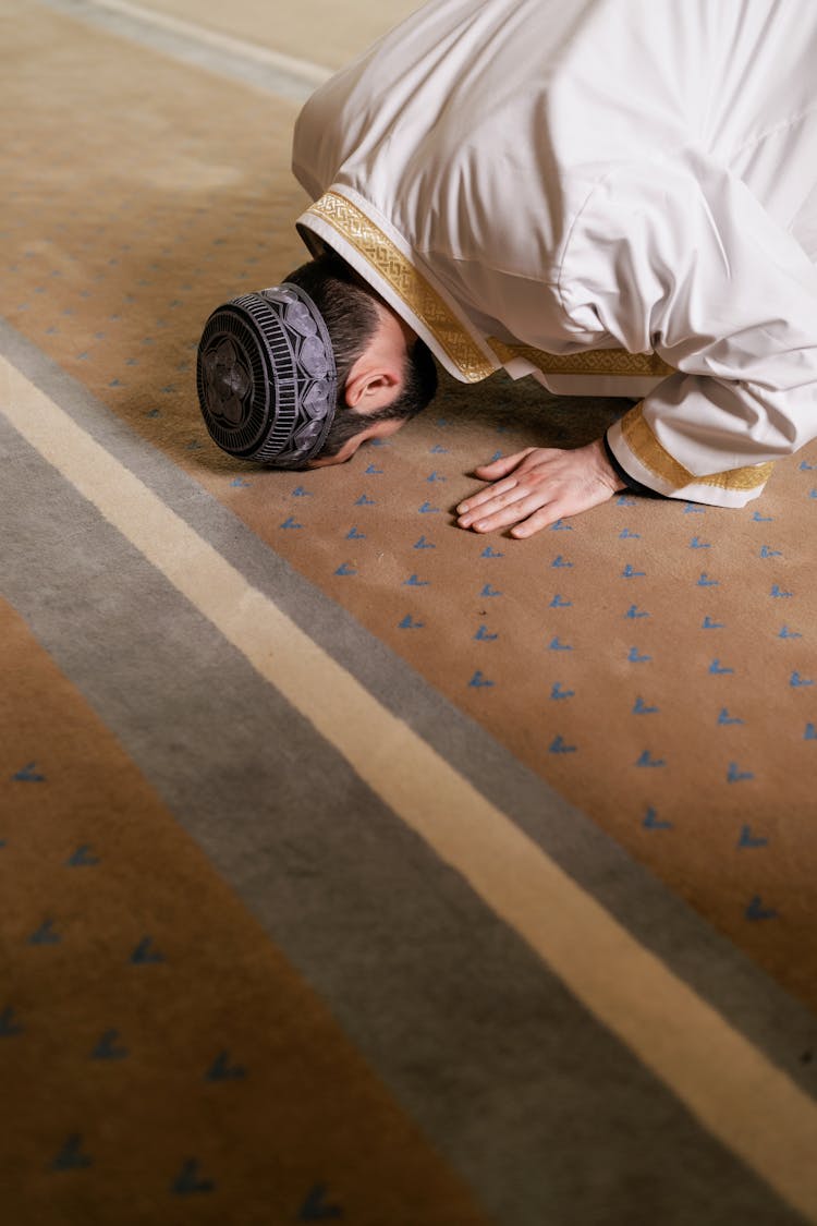 Man In White Thobe Kneeling And Bowing Down