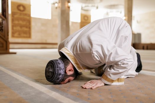 Man in White Thobe Bowing Down on the Floor