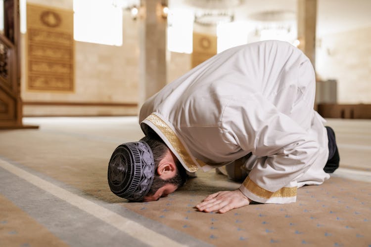 Man In White Thobe Bowing Down On The Floor