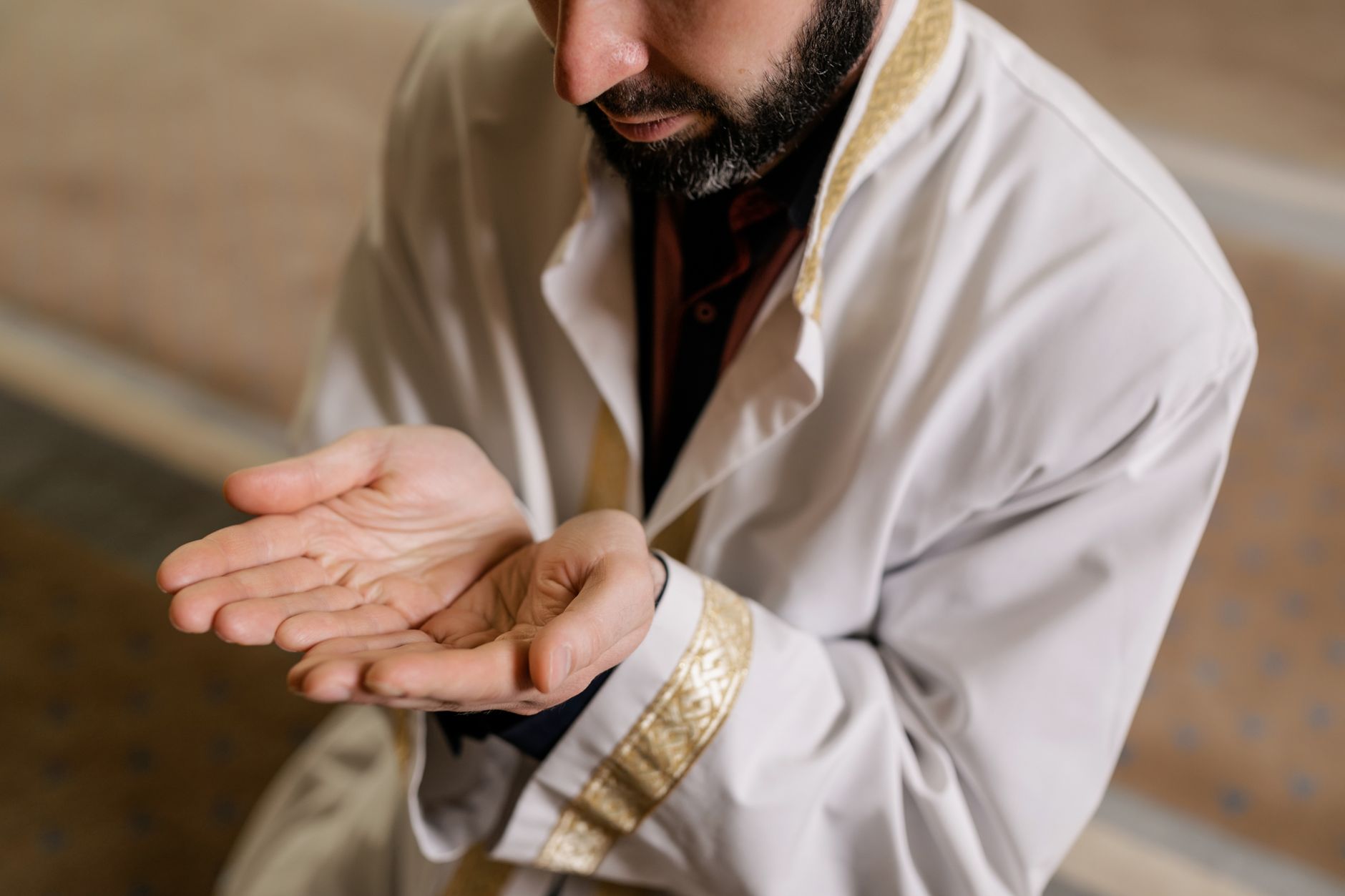 A Muslim man kneeling and praying inside a mosque, showcasing cultural and religious practices.
