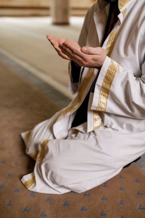 A Person in White Thobe Kneeling