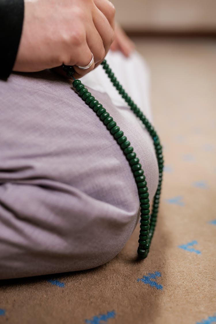 A Person Holding A Prayer Beads