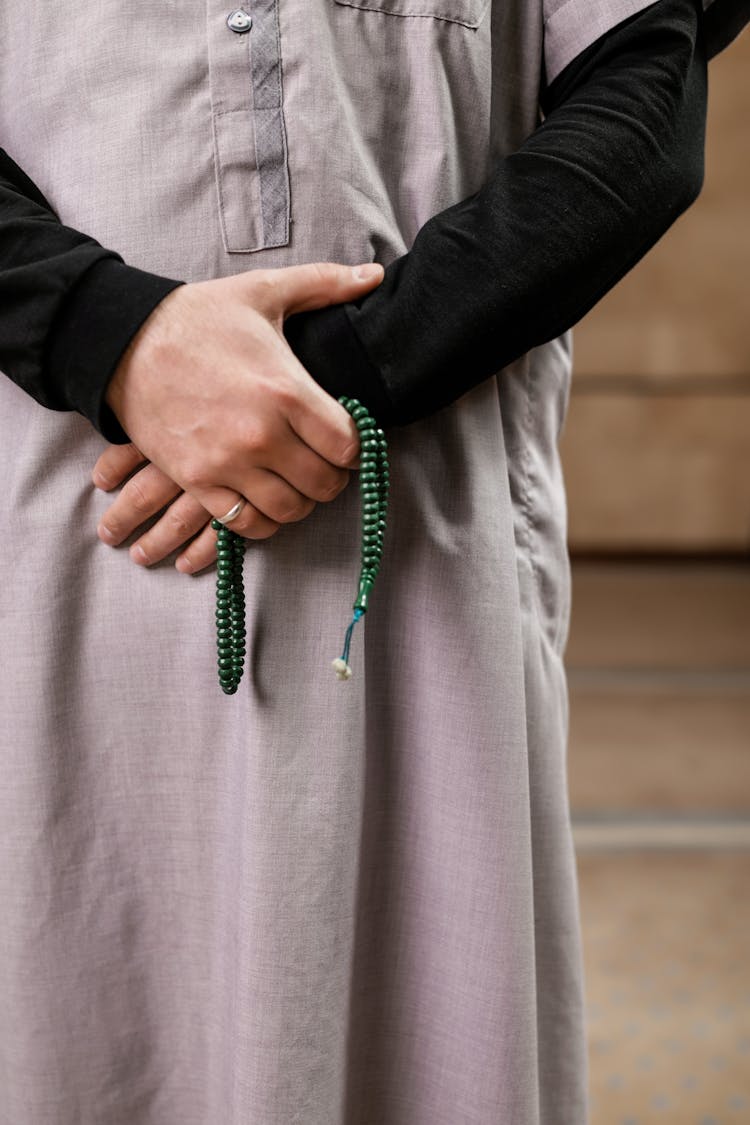 A Person Holding A Prayer Beads