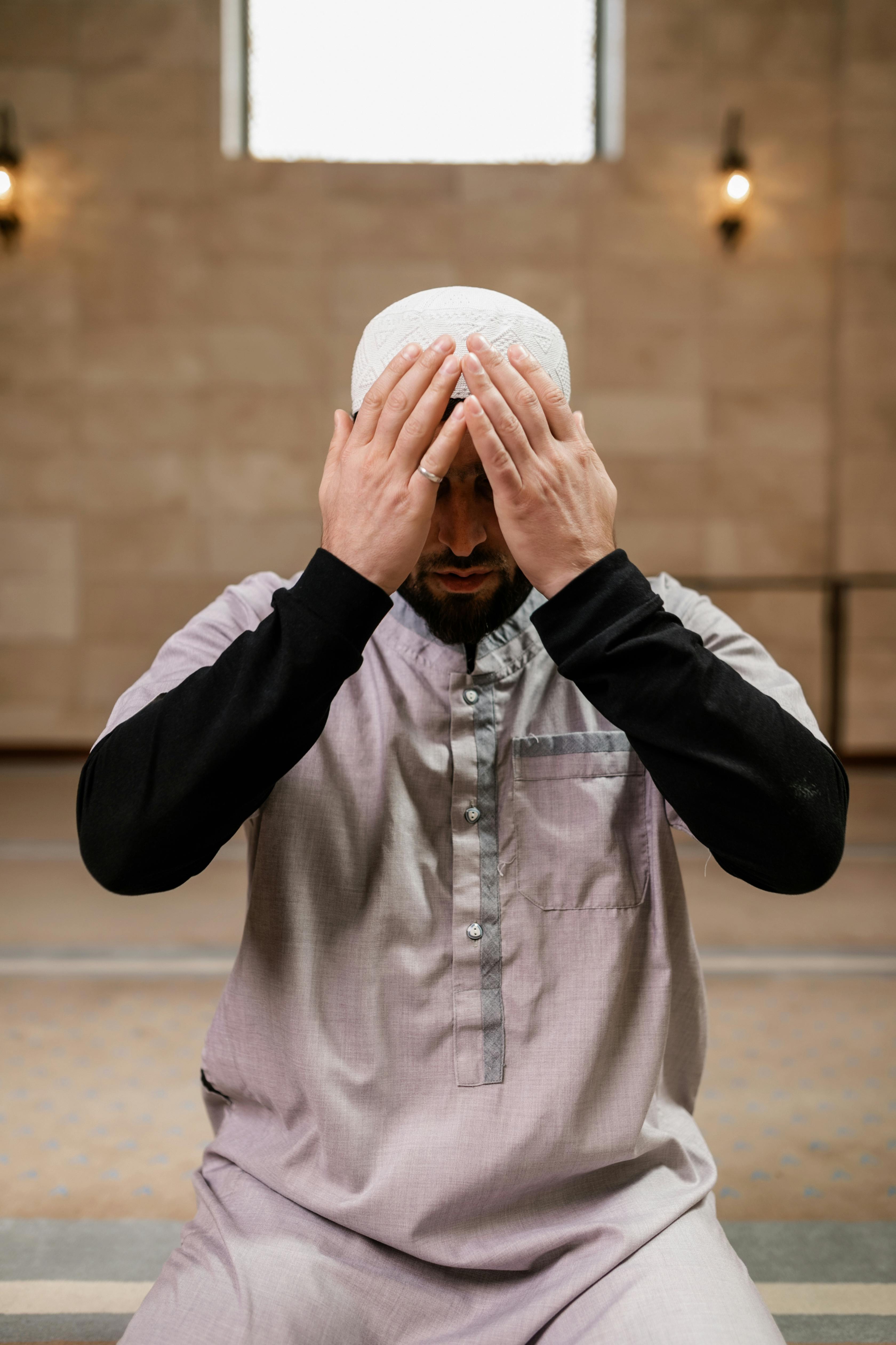 man kneeling on the floor while praying