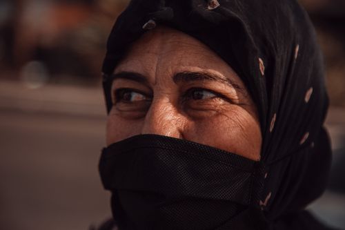 Free Close-up portrait of a mature Middle Eastern woman wearing a hijab and mask outdoors. Stock Photo