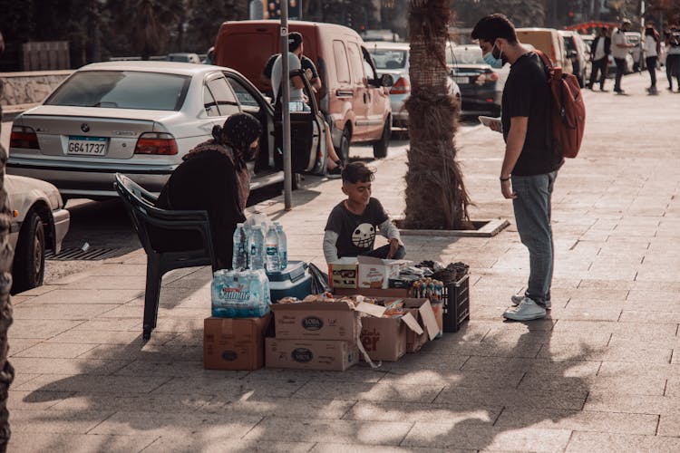 Mother And Son Selling Snacks On Street