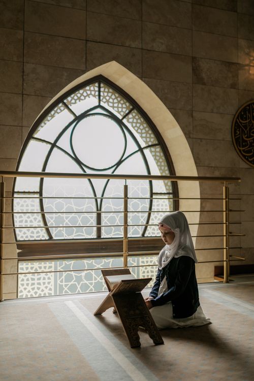Free A woman prays inside a mosque, wearing traditional attire, reflecting Islamic culture and devotion. Stock Photo