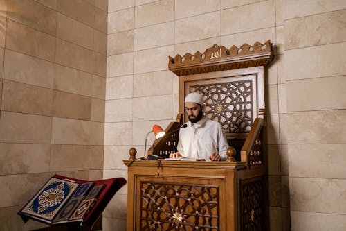 Man in White Thobe Sitting on Brown Wooden Chair