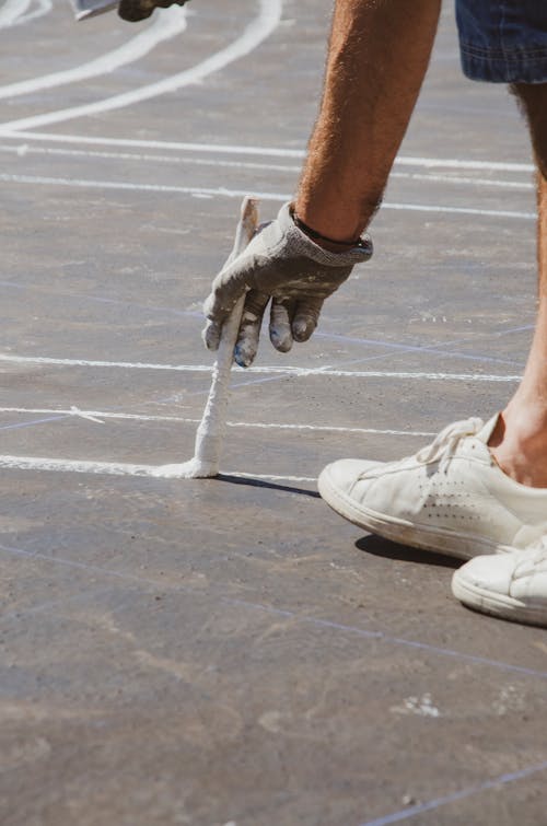 Painting White Lines with a Brush on the Asphalt