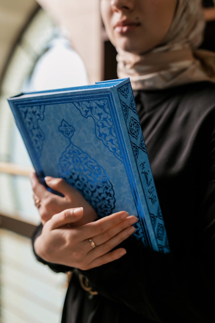 Woman Holding A Book With Blue Cover