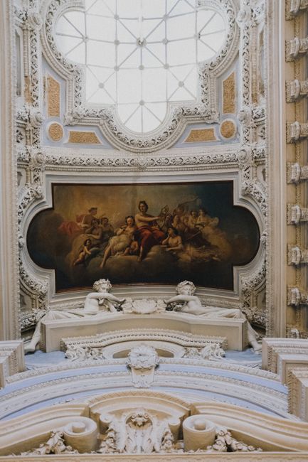 Intricately ornate Baroque ceiling with fresco art in a historic palace interior.