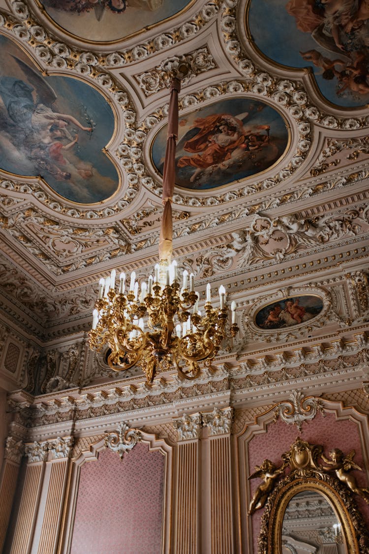 Golden Chandelier Under The Ornate Ceiling Of The Palace Chamber Decorated With Frescoes